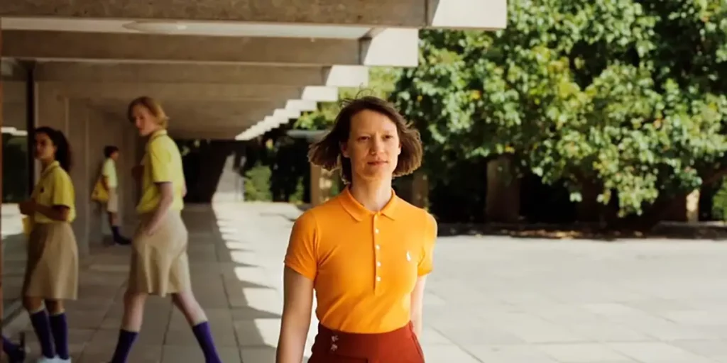 Mia Wasikowska walks with some students behind her in the film Club Zero