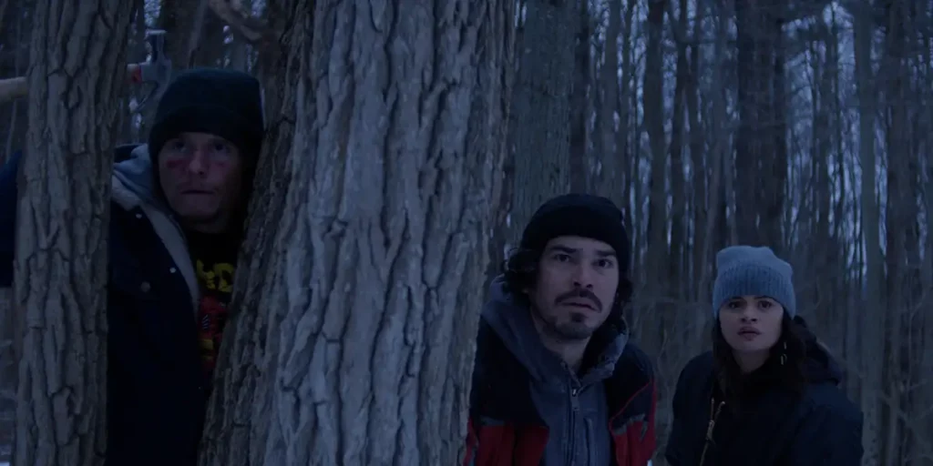 Three people next to a tree in the film Cold Wallet