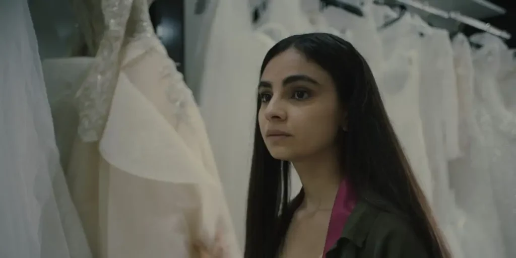 the protagonist of the film Elaha stands next to wedding dresses