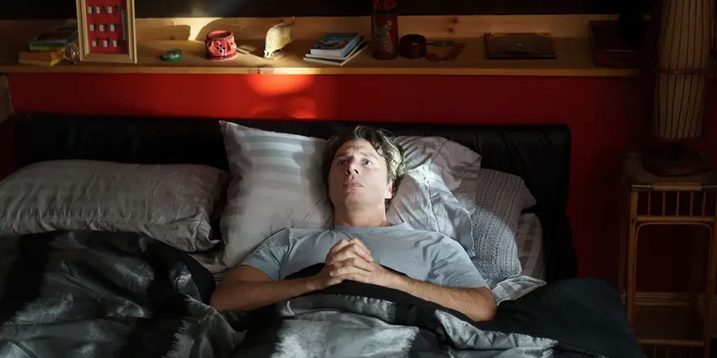 Zach Braff in bed as Gordon Kinski in the romantic comedy French Girl