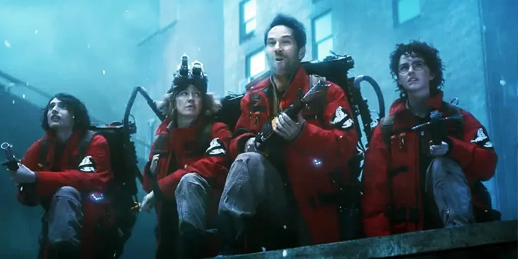 Four characters of Ghostbusters: Frozen Empire stand wearing red uniforms ready to catch ghosts