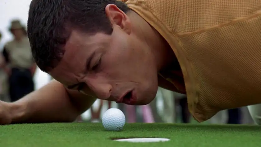 Adam Sandler blows on a golf ball in the film Happy Gilmore