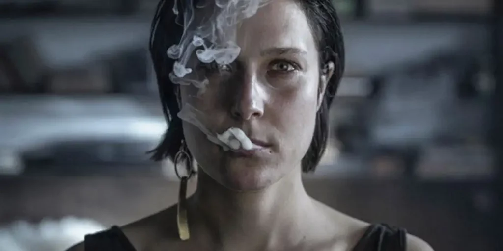 A woman has smoke coming out of her mouth in the film Imago