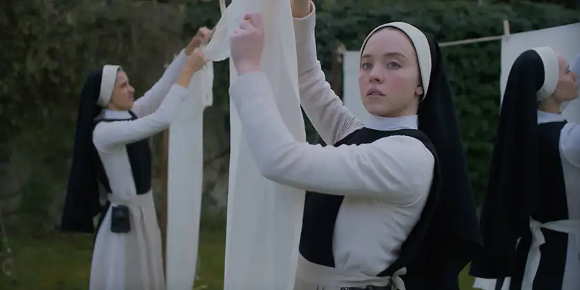 Sydney Sweeney puts clothes up to dry dressed as a nun in the film Immaculate