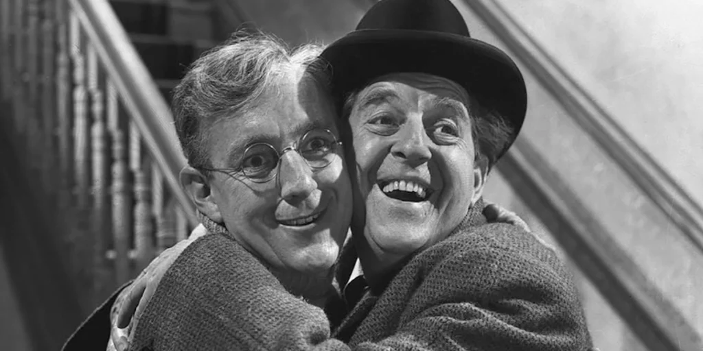 Two characters hug each other smiling in in the film The Lavender Hill Mob