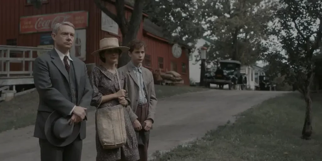 Three people stand on the side of the road, waiting, in the film Queen of Bones