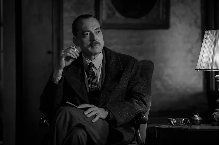 Maurizio Lombardi sits on an armchair and smokes as Inspector Ravini in Episode 108 of the series Ripley