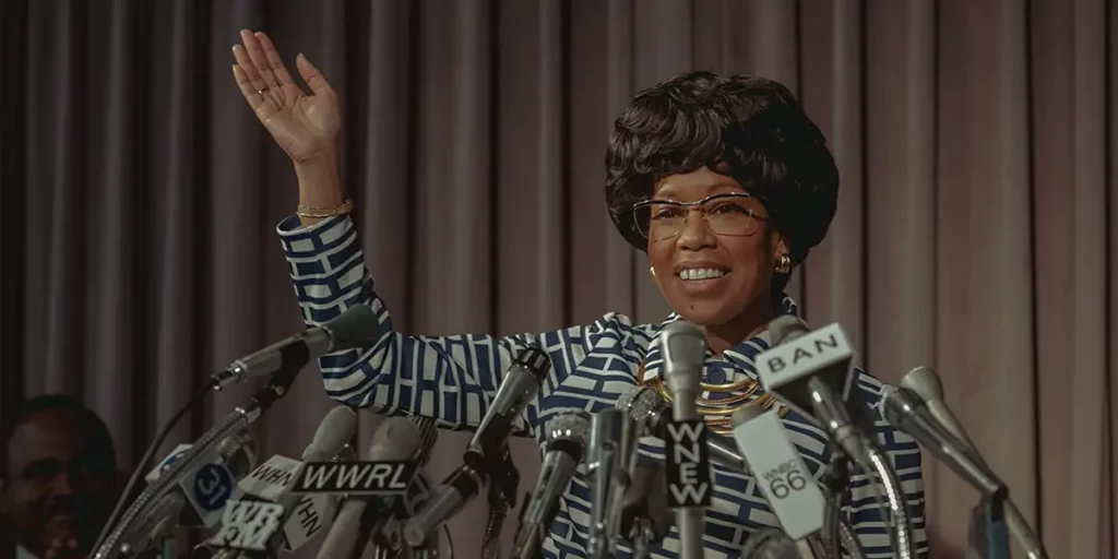Regina King as Shirley Chisholm waves and smiles while doing a speech in the 2024 Netflix film Shirley