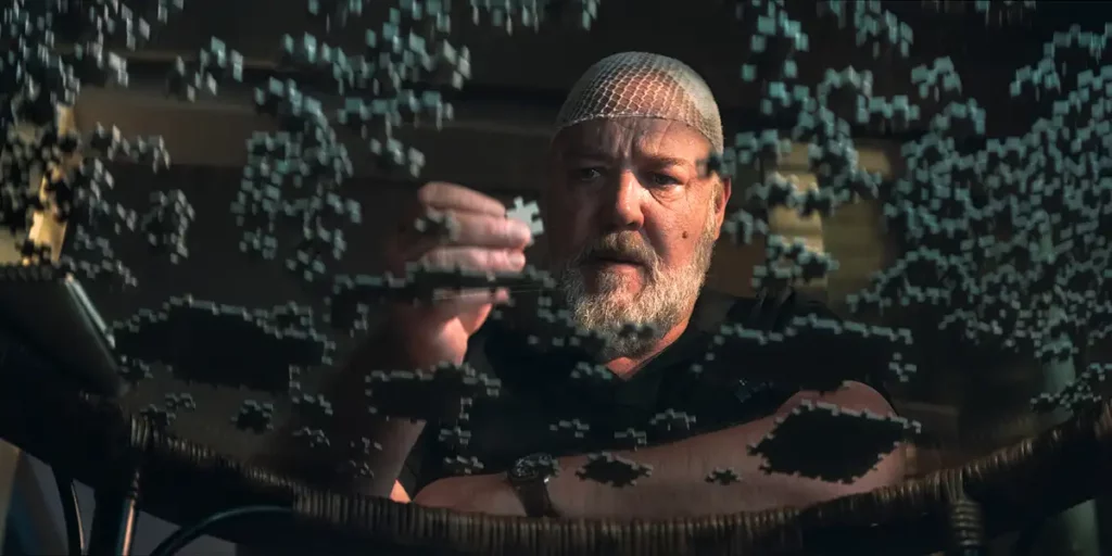 Russell Crowe holds a piece of a puzzle looking over a glass table in the film Sleeping Dogs