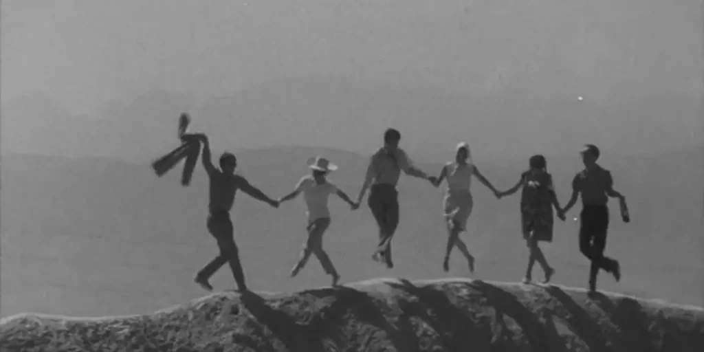 People hold hands on a hill in a still from the 1967 film Tenderness (Nezhnost)