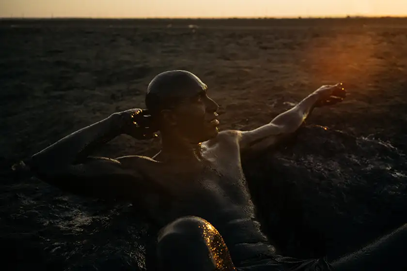 A man sits on the ground by the sunlight in the film The Black Sea