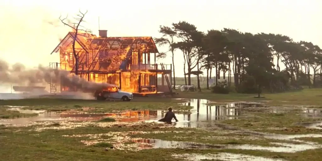 A man walks toward a burning house a still from Andrei Tarkovsky's film The Sacrifice