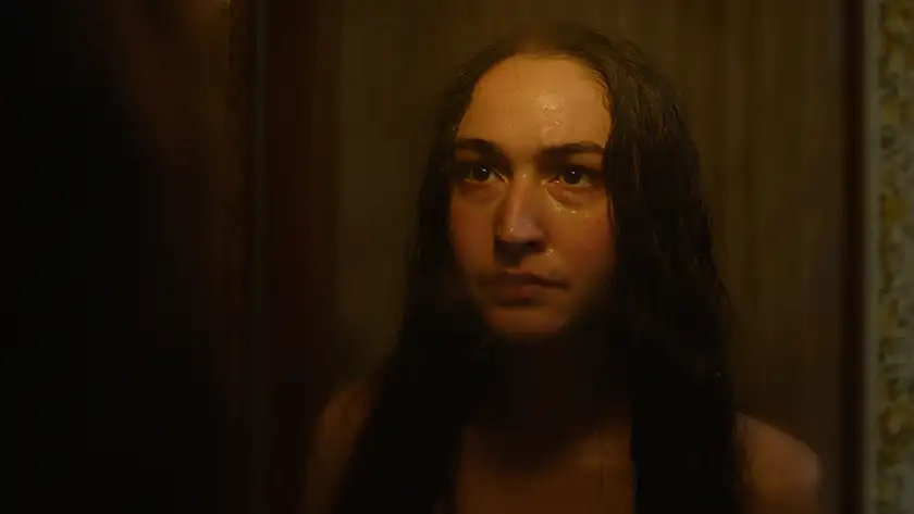 Jordan Cowan as “The Visitor” stands in front of a mirror in Indianna Bell and Josiah Allen’s Shudder film You’ll Never Find Me