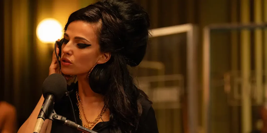 Marisa Abela as Amy Winehouse is on the phone in the film Back to Black, looking to her right