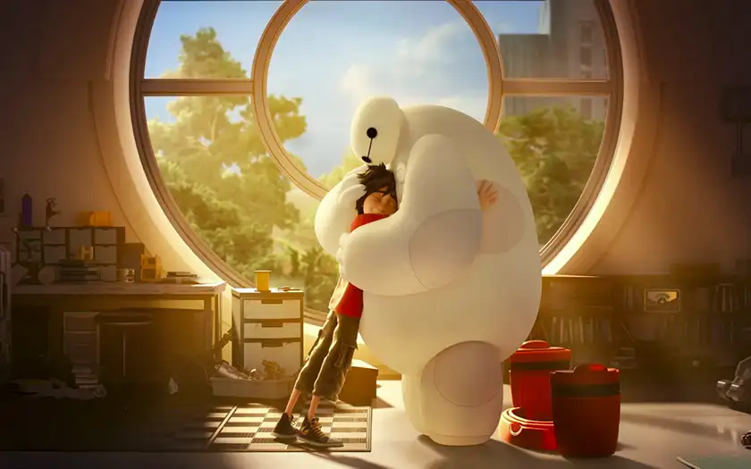 A big robot named Baymax and a young boy with black hair hug each other tight in front of a round window in the film Big Hero 6