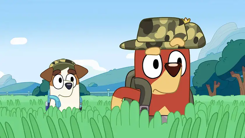 Two animated dogs stand in the middle of high grass weating army hats