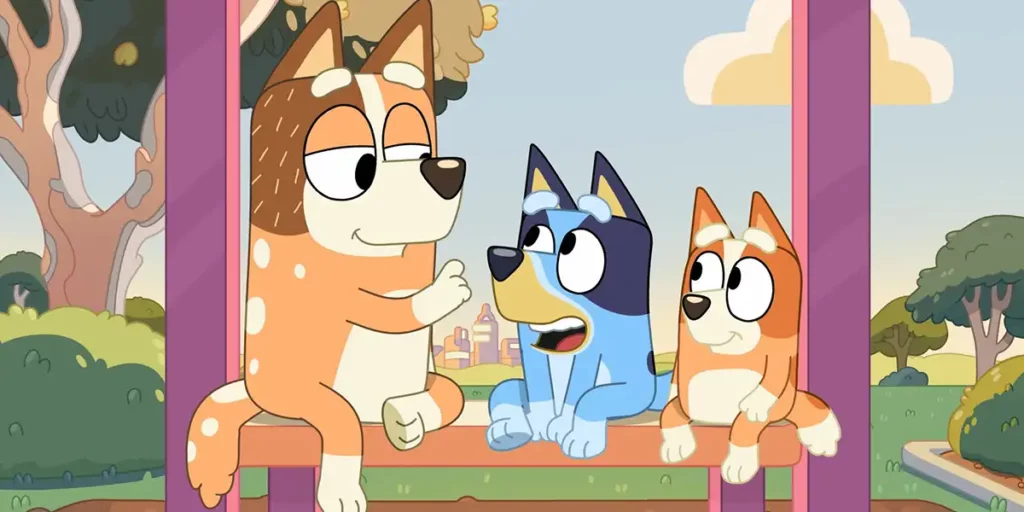 Three main characters of the series Bluey sit on a bench