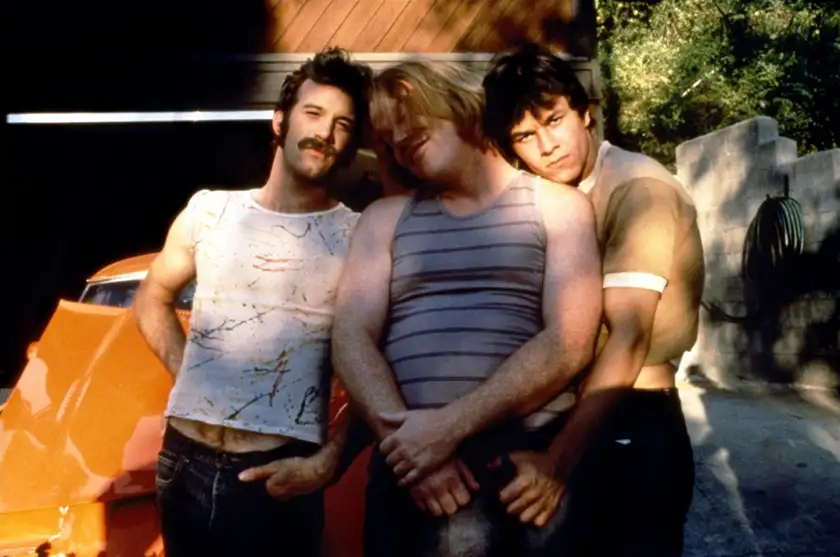 Three characters lean onto each other in the film Boogie Nights