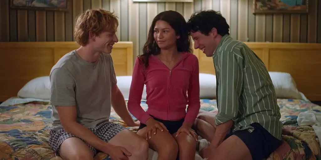 Zendaya sits on a bed between Mike Faist and Josh O’Connor in the 2024 film Challengers