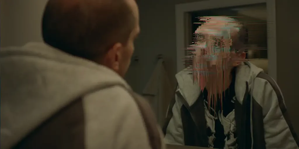 A man looks at a mirror and sees a pixelated, blurred version of his face in the Paramount+ series CTRL+ALT+DESIRE