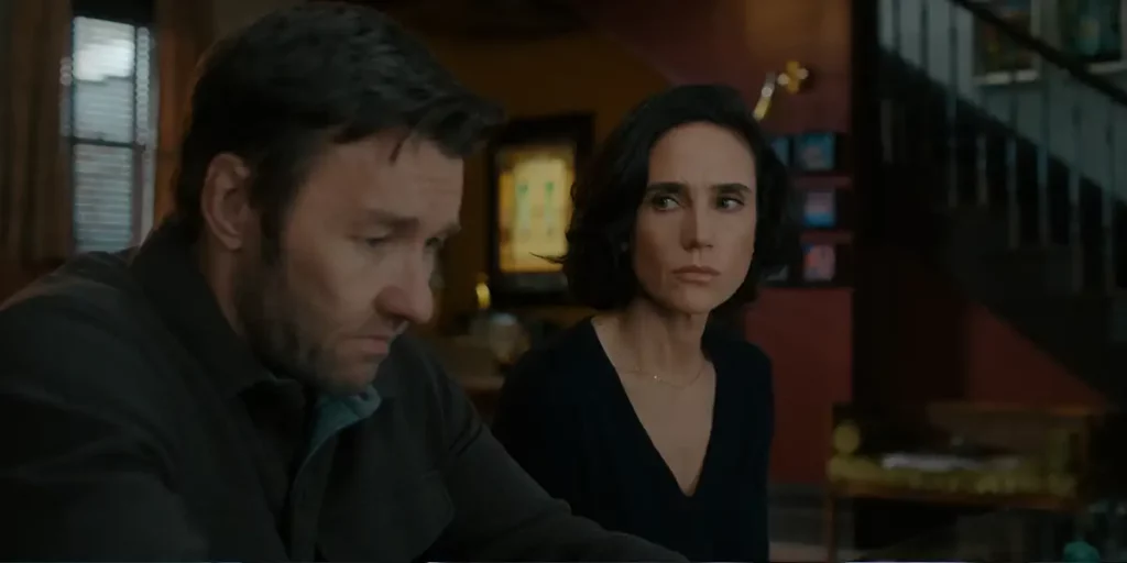 Joel Edgerton and Jennifer Connelly look at each other sitting in a house in the Apple TV+ series "Dark Matter"