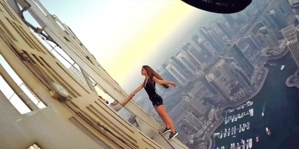 A woman holds on to the bars of a tower high in the sky in the documentary film Fantastic Machine