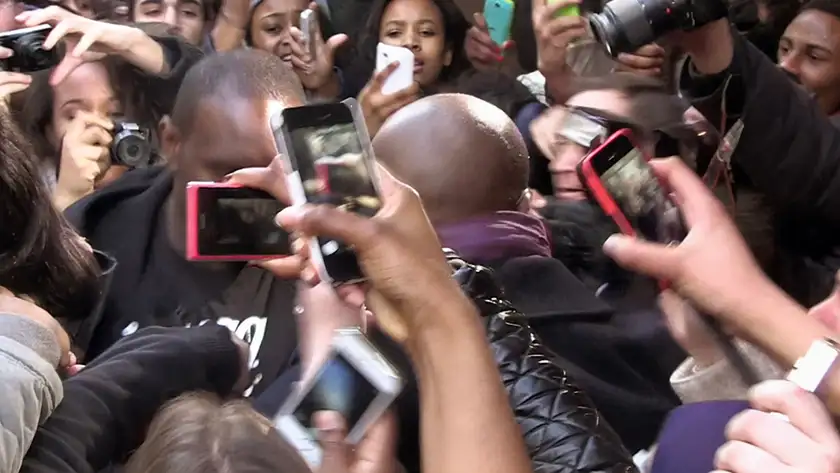 People hold mobile phones up in a crowd to take a photo of someone famous in the documentary film Fantastic Machine
