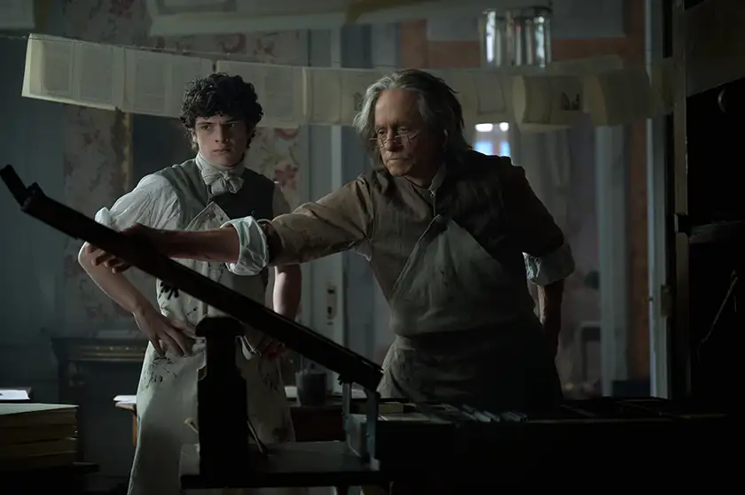 Noah Jupe and Michael Douglas use the printing press in the series premiere of Franklin