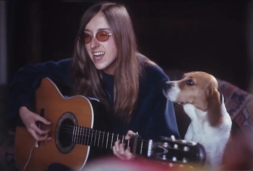 Judee Sill sings and plays the guitar sitting on a couch with her dog next to her in the documentary film Lost Angel: The Genius of Judee Sill