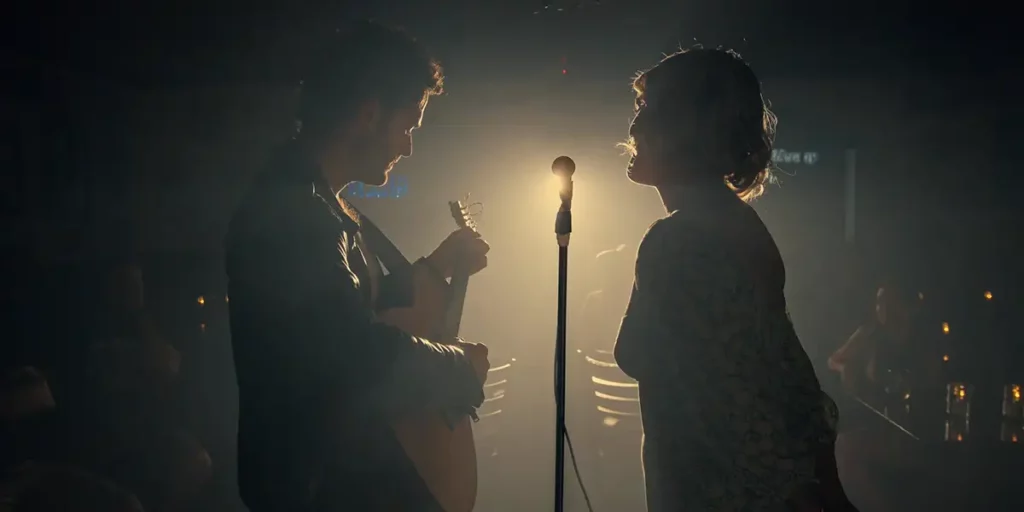 two people are on a stage singing by a microphone in the film Pure O