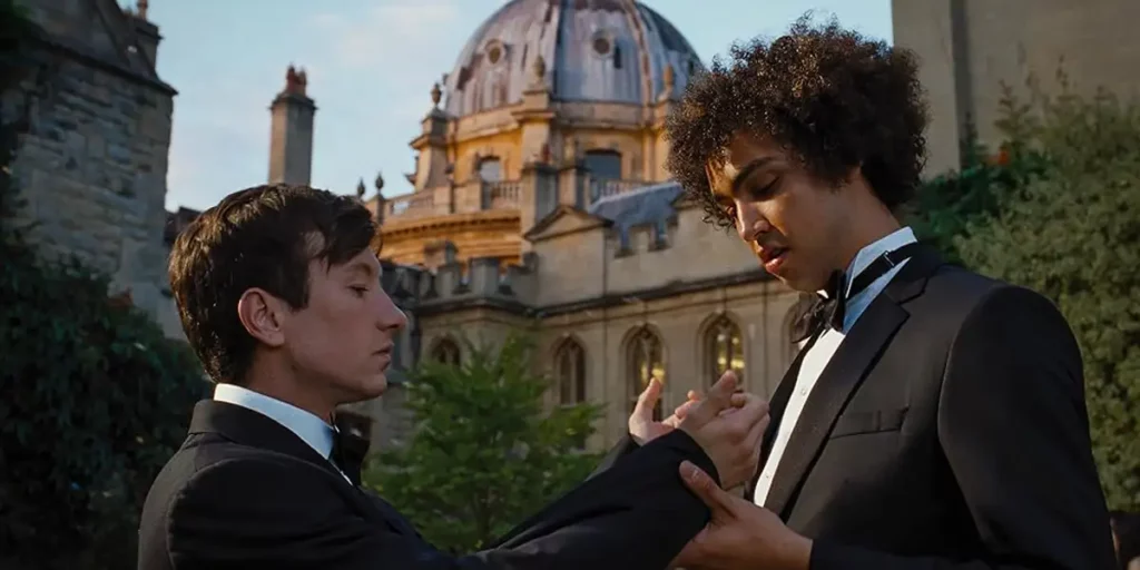 Barry Keoghan and Archie Madekwe stand outside Oxford university in the movie Saltburn, whose ending is explained in this article