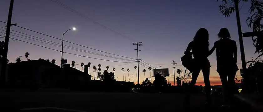 The outline of two girls is dark against a sunset in a city in the movie Tangerine, one of the most recent films by Sean Baker ranked from worst to best