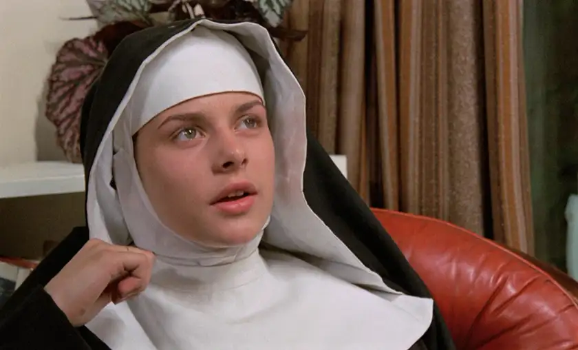 A nun sits on an armchair and looks up in To the Devil a Daughter, one of the 5 Movies to Watch if you Liked The First Omen according to Loud and Clear Reviews