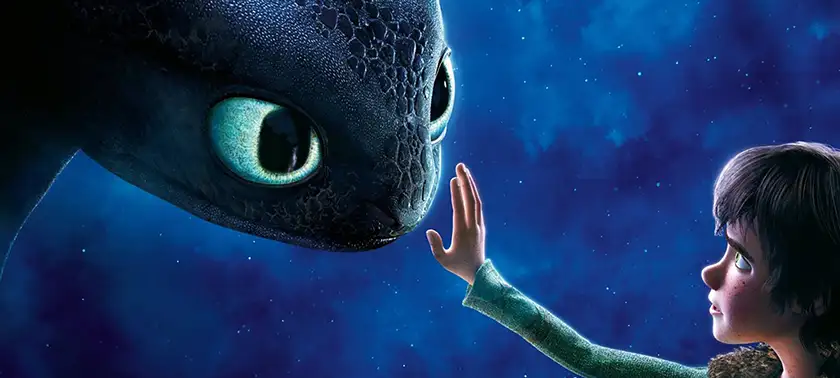 A boy puts his hand close to a dragon's face in How to Train Your Dragon, one of the 5 Age Appropriate Movies for 12 Year Olds recommended by Loud and Clear Reviews