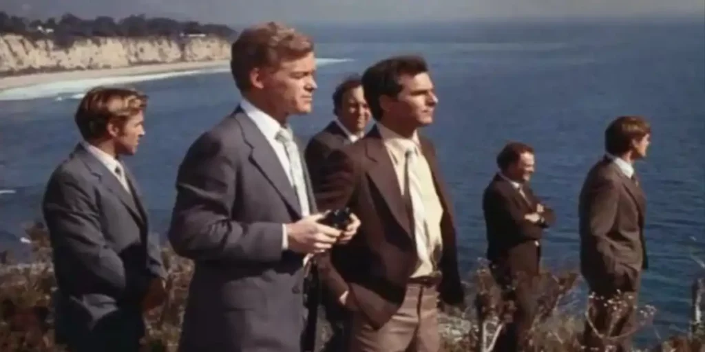 A group of men look to their left standing in front of the sea in Episode 12 of Wonder Woman (1975)