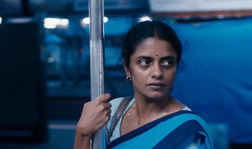 An indian woman wears a blue dress in the underground in the film All We Imagine As Light