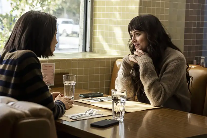 Sonoya Mizuno and Dakota Johnson sit at a table in a diner opposite each other in the Max film Am I OK?