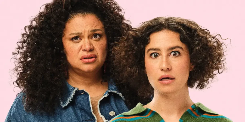 Michelle Buteau and Ilana Glazer look worried in the pink poster of the film Babes