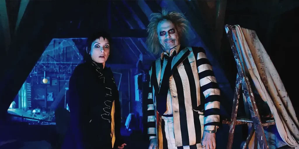 Winona Ryder and Michael Keaton stand looking down at something, the former in fear and the latter with excitement, in the film Beetlejuice Beetlejuice, from an article with everything we know about Beetlejuice 2