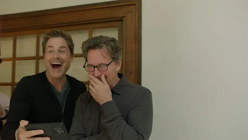 Rob Lowe and Andrew McCarthy look at a phone screen and laugh in the documentary Brats, one of the 15 films to watch at the Tribeca Film Festival according to Loud and Clear Reviews