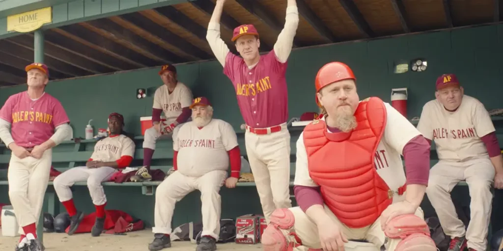 Baseball players wearing red and white uniforms watch from their seats in the film Eephus