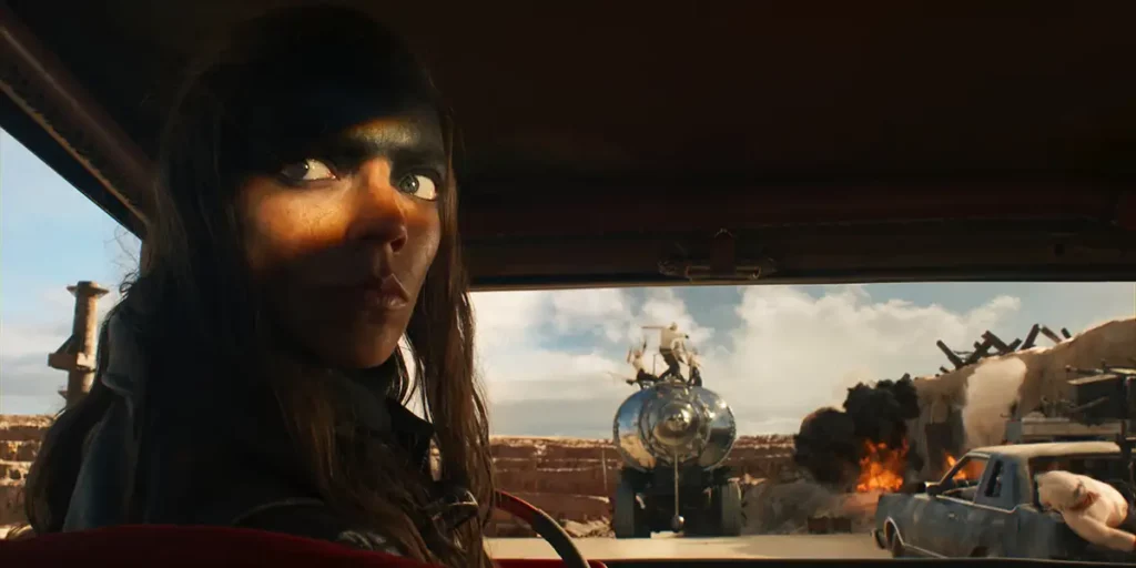 Anya Taylor Joy sits in a car and only her eyes are illuminated in FURIOSA: A MAD MAX SAGA