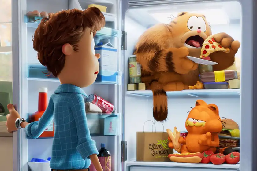 A cat and a dog are eating food in a fridge while a human watches them weirded out in The Garfield Movie