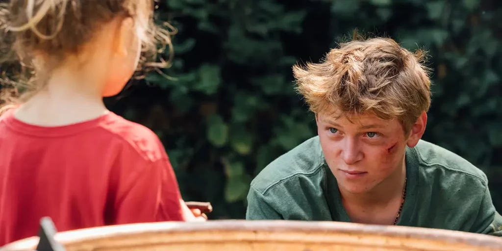 A boy looks at a young girl in the film Holy Cow (Vingt Dieux)