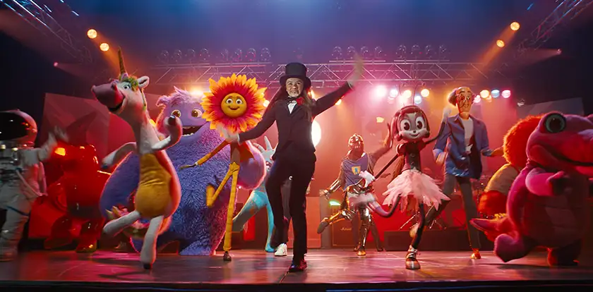 Imaginary friends dance on a colorful dance floor in the film IF