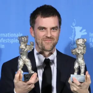 Director Paul Thomas Anderson holds two Berlinale bears and smiles