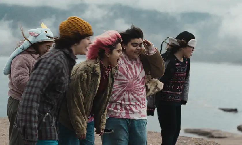 Teenagers stand on the beach in the wind and shout in the film Simon of the Mountain