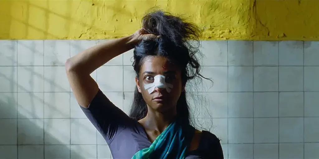 An Indian woman holds her hair up with a plaster over her nose in the film Sister Midnight