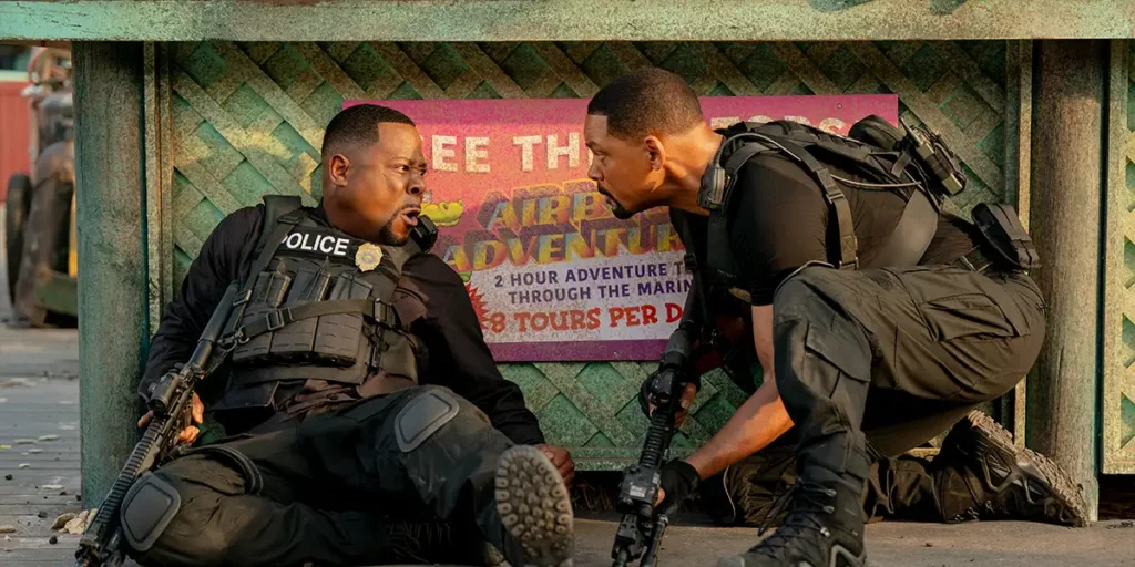 Martin Lawrence and Will Smith are on the ground talking in the film BAD BOYS: RIDE OR DIE.