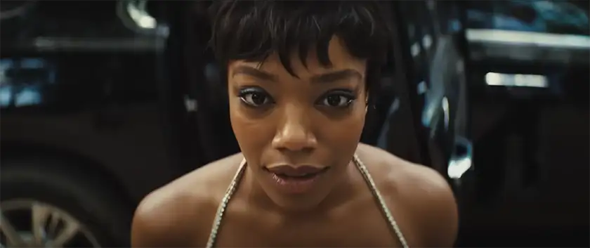 Naomi Ackie looks directly at the camera in a scene from the Zoë Kravitz movie Blink Twice, used in an article with everything we know about the film